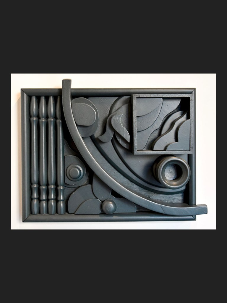 Abstract wall sculptural art made from reclaimed wooden elements featuring a variety of grey geometric shapes and patterns arranged in a rectangular frame by David Furman