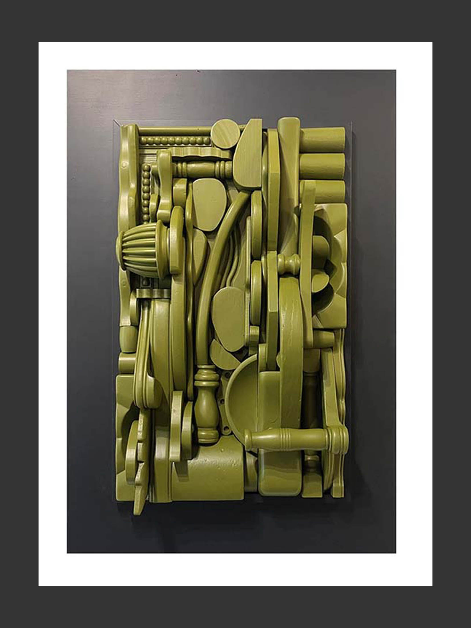 A relief artwork made from reclaimed wooden objects, arranged in a textured, abstract manner and painted green with a dark frame by David Furman.
