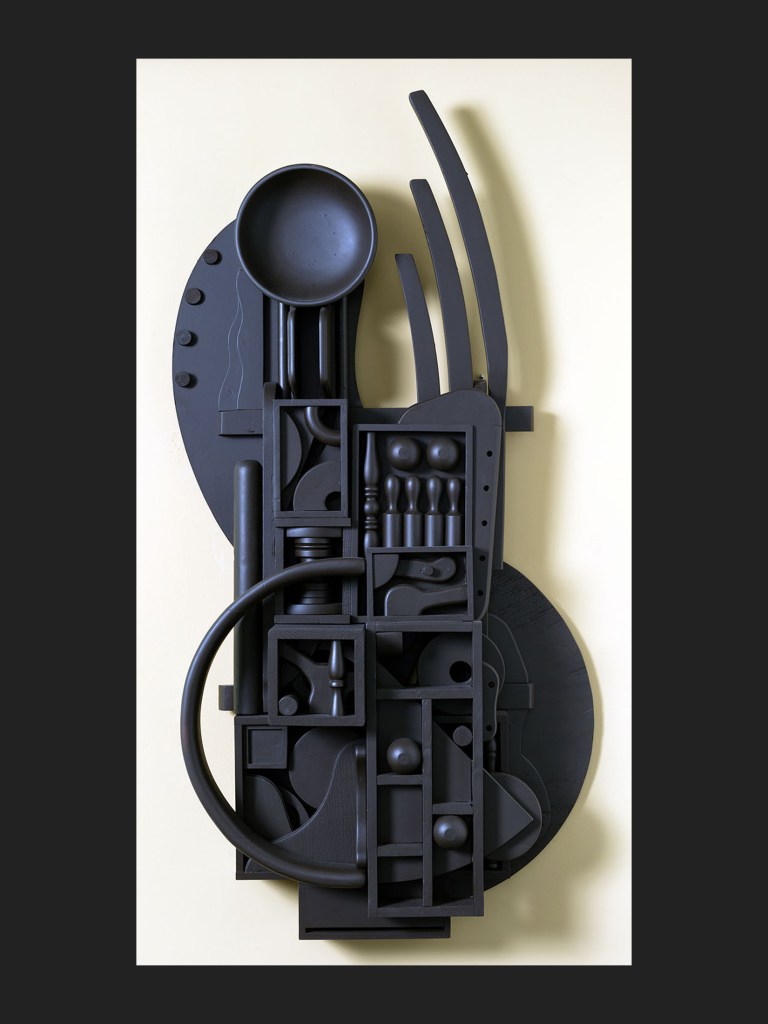A monochromatic dark gray/deep purple wall sculpture artwork made from reclaimed wooden elements and composed of various geometric shapes and utensils, arranged in a layered, abstract design against a light-colored background by David Furman