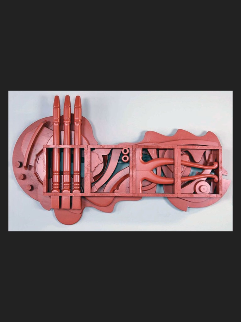 A colorful, abstract wooden wall art sculpture made from reclaimed and rearranged wooden elements featuring various shapes and sections including cylindrical and curved forms, primarily in shades of red by David Furman