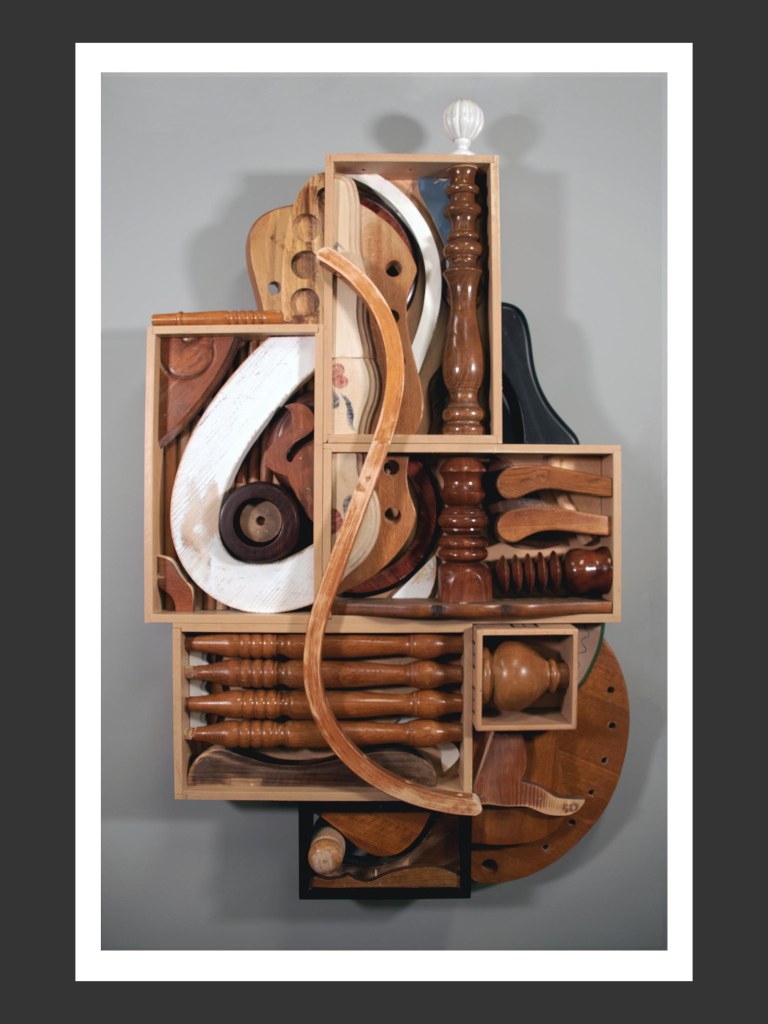 A wall sculpture of reclaimed wood forming creative arrangement of various wooden shapes and sculptures displayed in a framed setting by David Furman