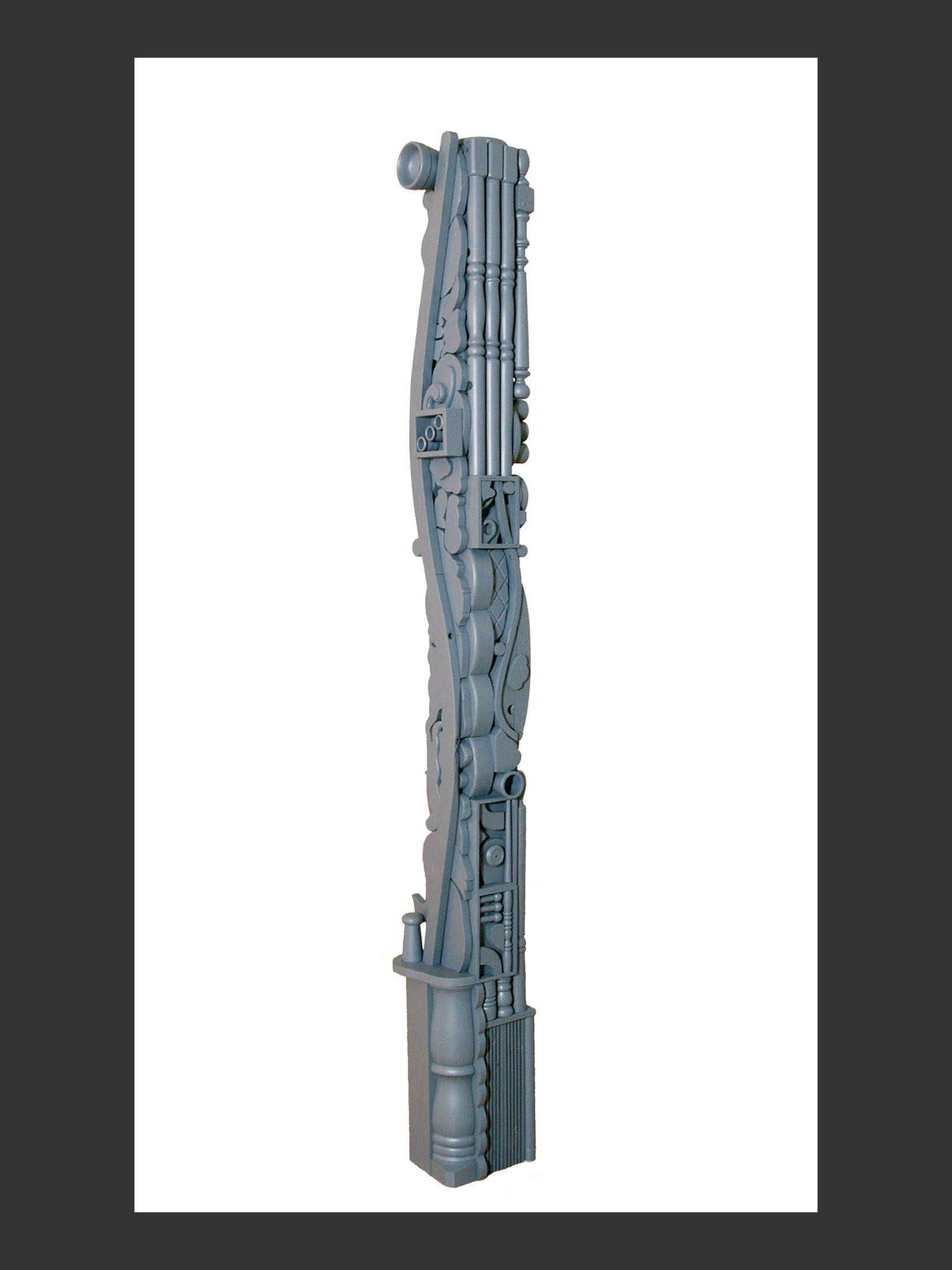 A detailed, gray-colored sculpture, or “Totem”, made from reclaimed wooden elements and featuring geometric forms and whimsical construction by David Furman.