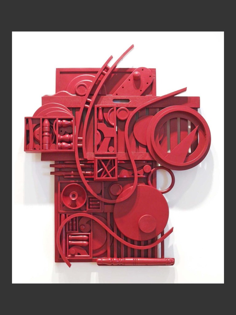 A contemporary wall sculpture made from reclaimed wooden elements forming an abstract red sculpture featuring various geometric shapes and textures arranged in a visually dynamic composition by David Furman